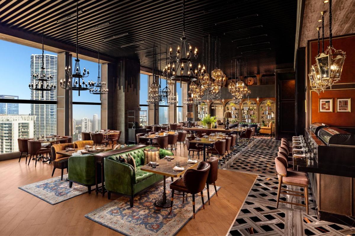 a restaurant with tables and chairs and large windows at The St. Regis Mumbai in Mumbai