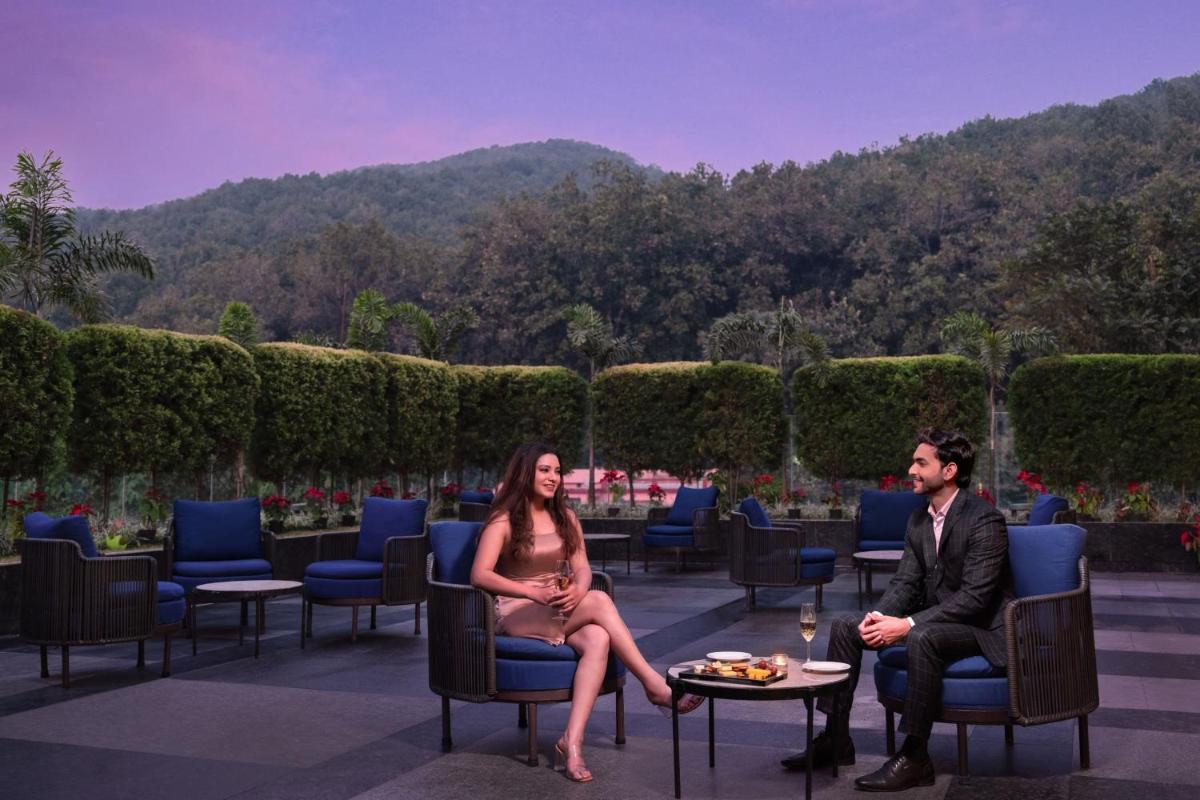 a man and woman sitting in chairs on a patio at Fairfield by Marriott Dehradun in Dehradun