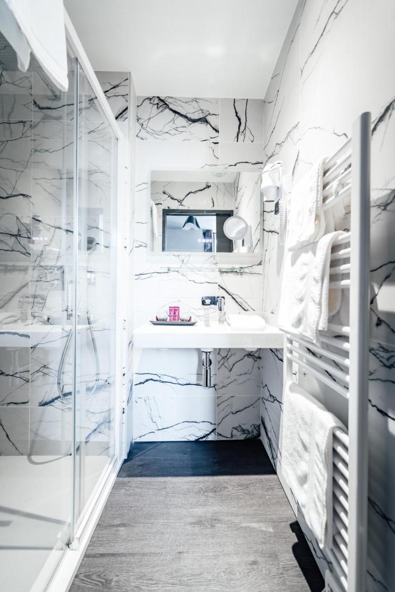 La salle de bains est pourvue de murs en marbre et d'un lavabo. dans l'établissement La villa 10 HÔTEL SPA, à Étretat 151 autres photos