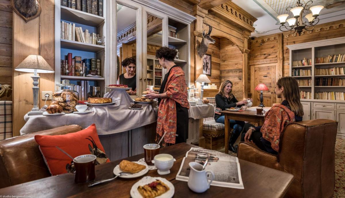 un groupe de personnes assises à des tables dans un restaurant dans l'établissement Hôtel Alpen Ruitor, à Méribel