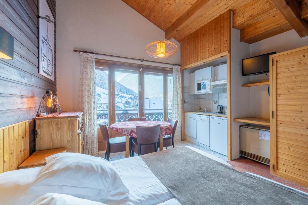 une chambre avec un lit et une table et une cuisine dans l'établissement Hôtel Les Côtes, Résidence Loisirs et Chalets, à Morzine