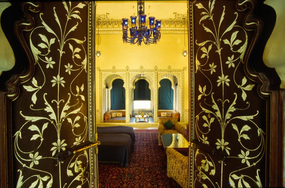 a room with a door with a mirror and a couch at Shiv Niwas Palace by HRH Group of Hotels in Udaipur
