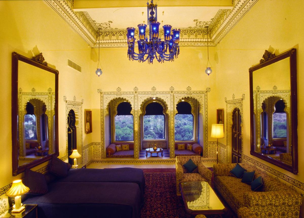 a living room with two couches and a chandelier at Shiv Niwas Palace by HRH Group of Hotels in Udaipur
