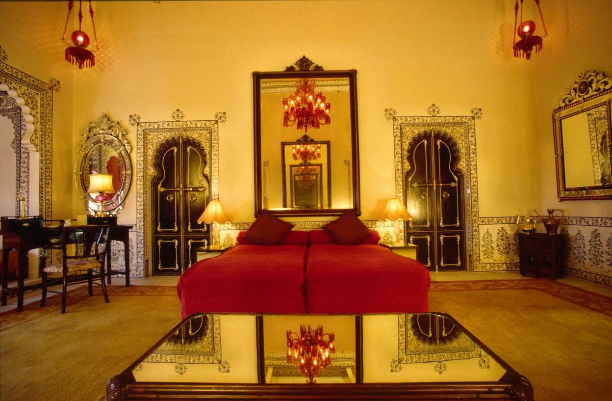 a bedroom with a red bed in a room at Shiv Niwas Palace by HRH Group of Hotels in Udaipur