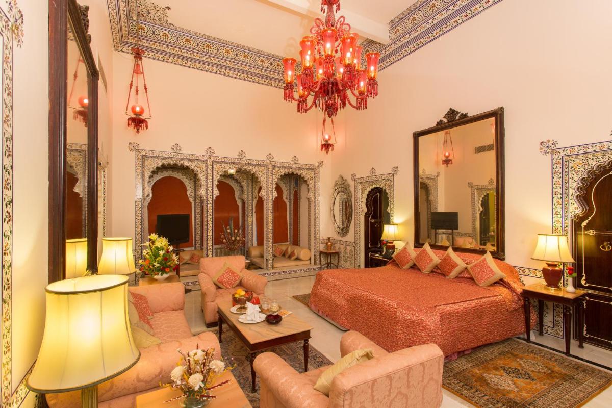 a bedroom with a bed and a living room at Shiv Niwas Palace by HRH Group of Hotels in Udaipur