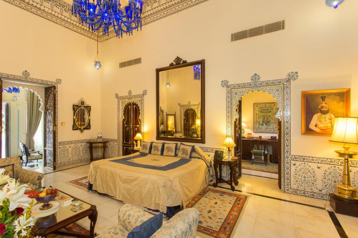 a bedroom with a bed and a large mirror at Shiv Niwas Palace by HRH Group of Hotels in Udaipur