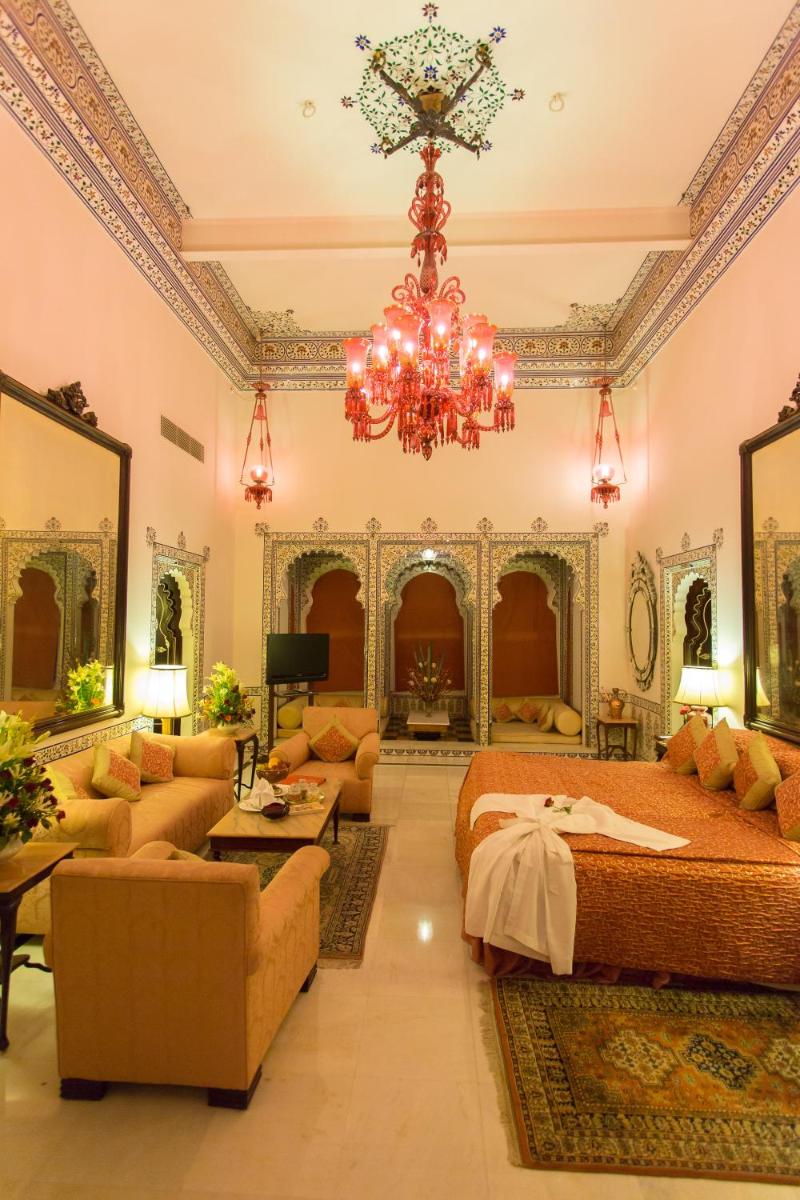 a large room with two beds and a chandelier at Shiv Niwas Palace by HRH Group of Hotels in Udaipur