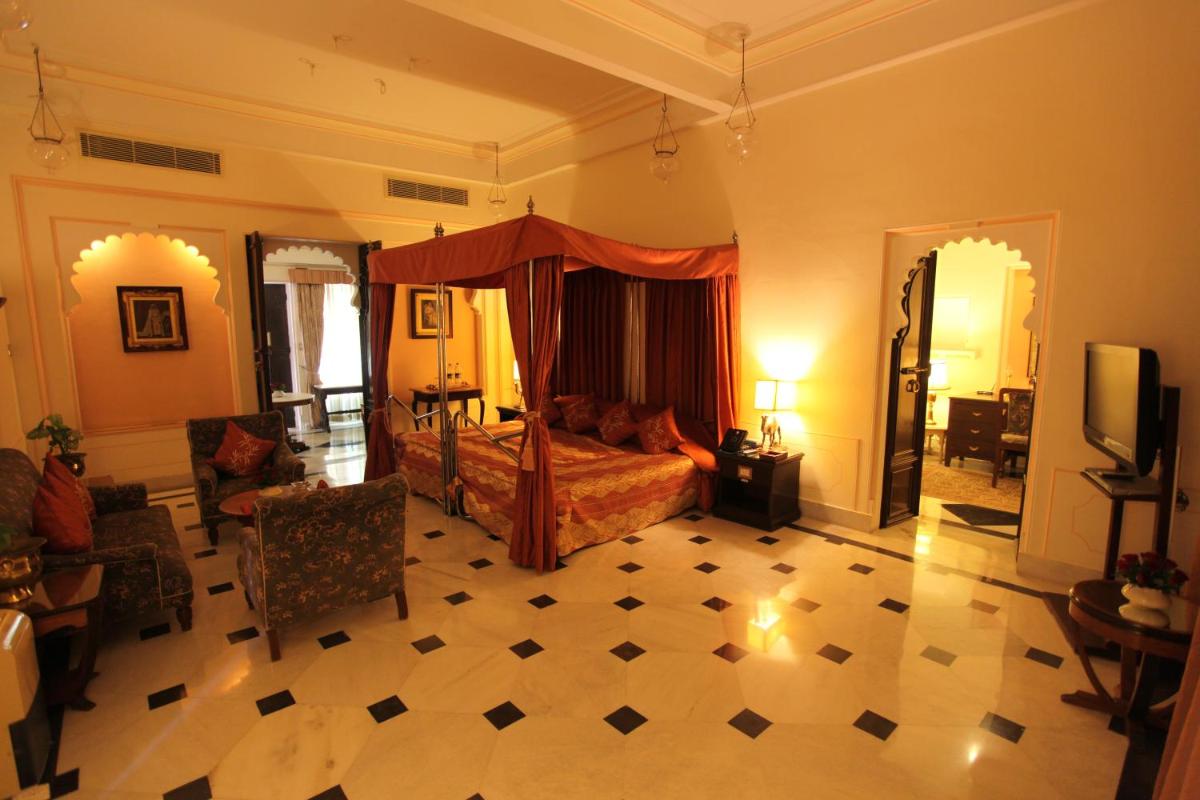 a bedroom with a bed and a living room at Shiv Niwas Palace by HRH Group of Hotels in Udaipur