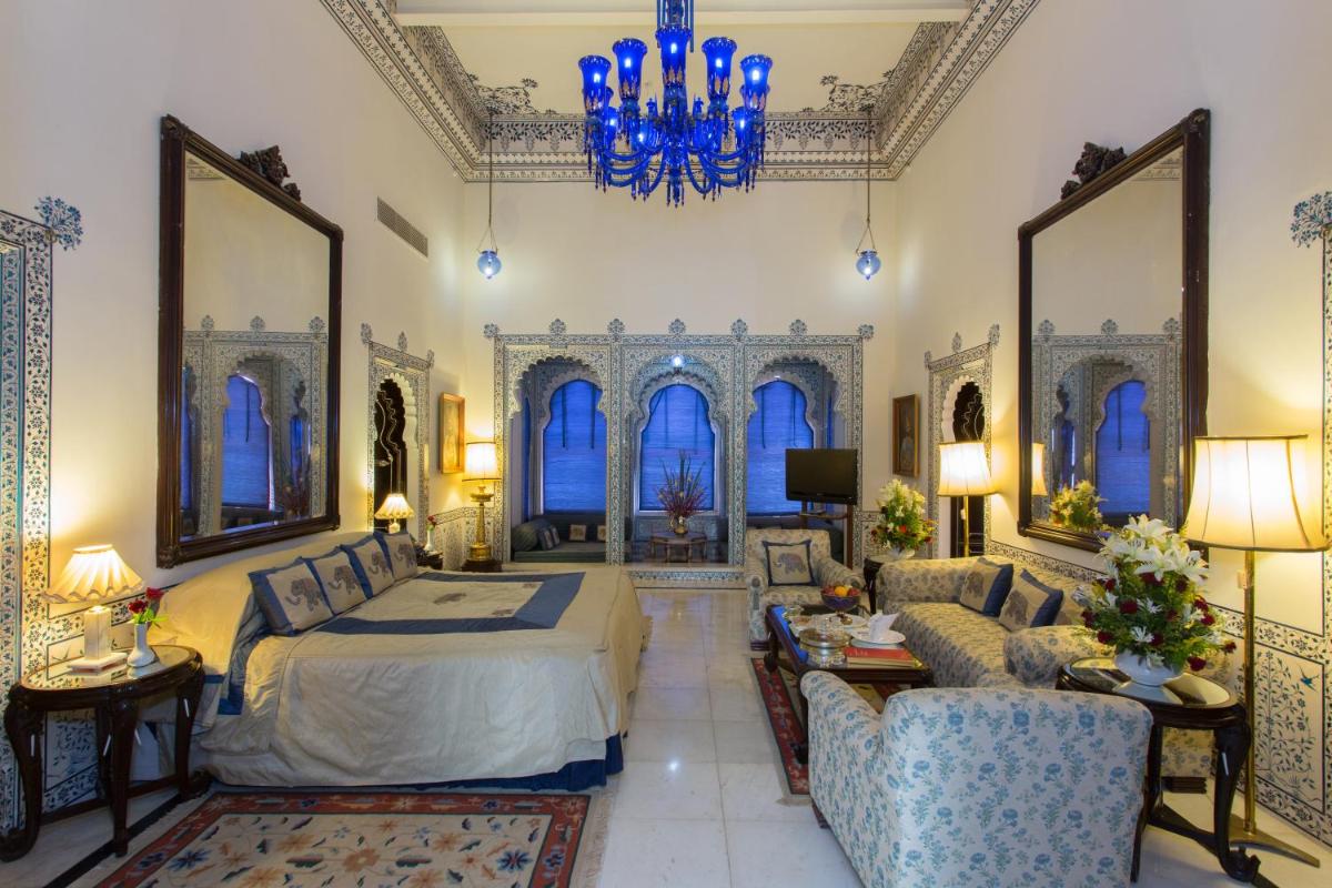 a bedroom with a bed and a living room at Shiv Niwas Palace by HRH Group of Hotels in Udaipur