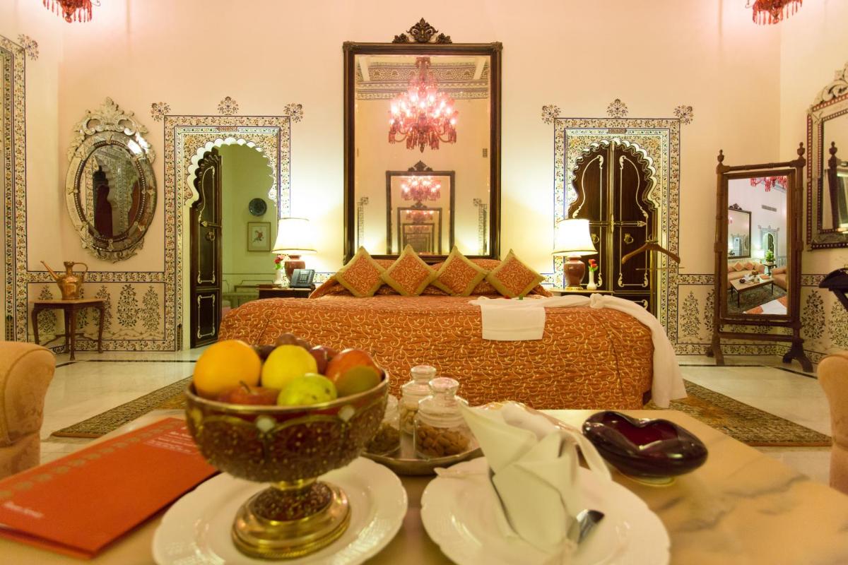 a bedroom with a bed and a bowl of fruit on a table at Shiv Niwas Palace by HRH Group of Hotels in Udaipur