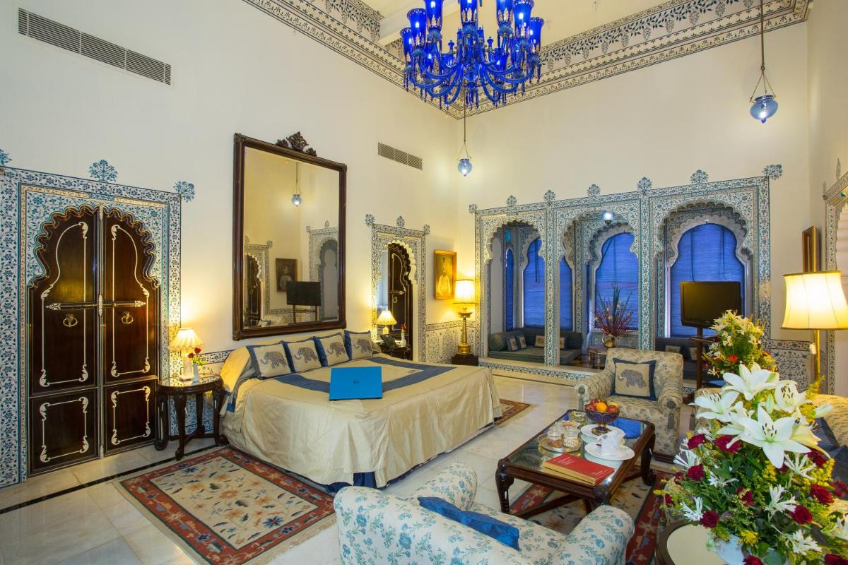 a large living room with a bed and a chandelier at Shiv Niwas Palace by HRH Group of Hotels in Udaipur