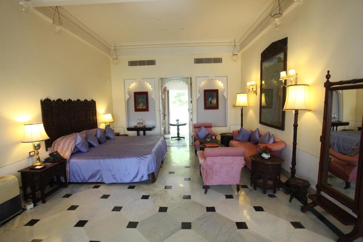 a bedroom with a bed and a living room at Shiv Niwas Palace by HRH Group of Hotels in Udaipur