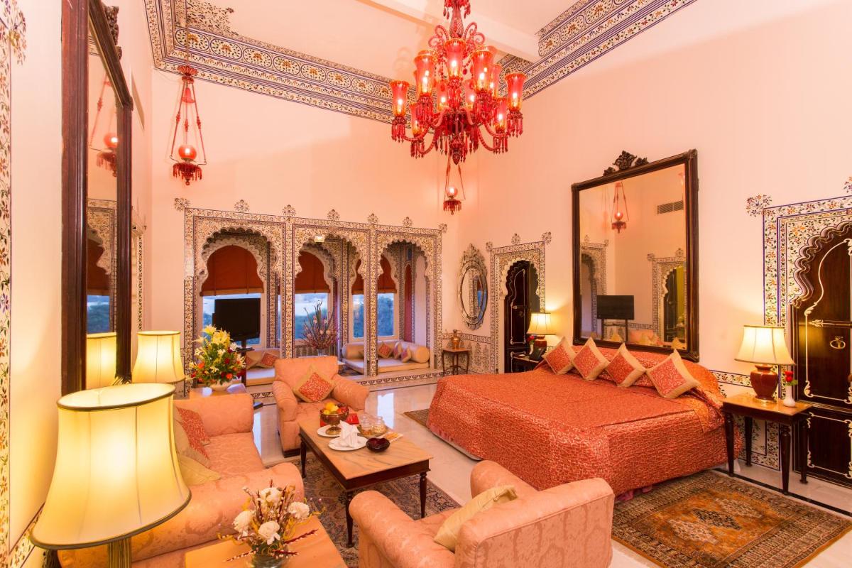 a bedroom with a bed and a living room at Shiv Niwas Palace by HRH Group of Hotels in Udaipur