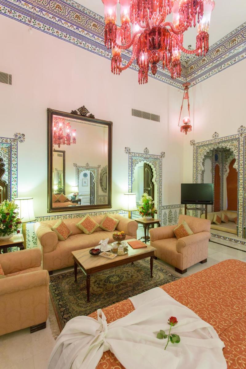 a living room filled with furniture and a mirror at Shiv Niwas Palace by HRH Group of Hotels in Udaipur