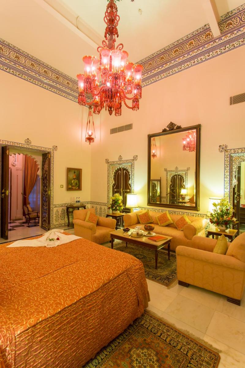 a bedroom with a bed and a chandelier at Shiv Niwas Palace by HRH Group of Hotels in Udaipur