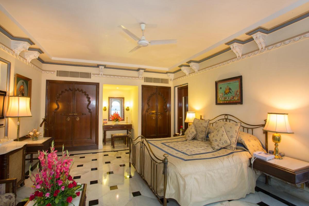 a bedroom with a bed and a desk and a room at Shiv Niwas Palace by HRH Group of Hotels in Udaipur