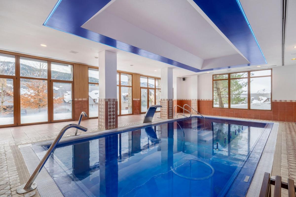 una gran piscina con techo azul en Eurostars Royal Tanau, en Baqueira Beret una gran piscina con techo azul en Eurostars Royal Tanau, en Baqueira Beret