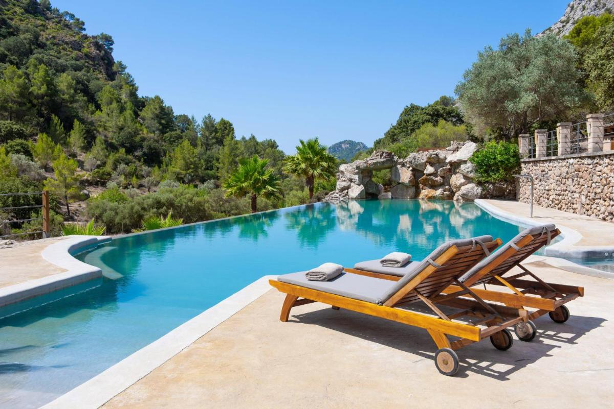 un par de sillones junto a una piscina en Finca Ratxo Hotel, member of Melia Collection, en Puigpunyent