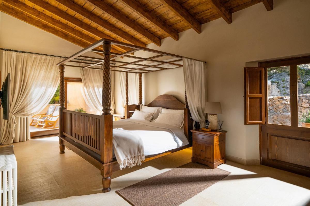 1 dormitorio con cama con dosel y porche en Finca Ratxo Hotel, member of Melia Collection, en Puigpunyent