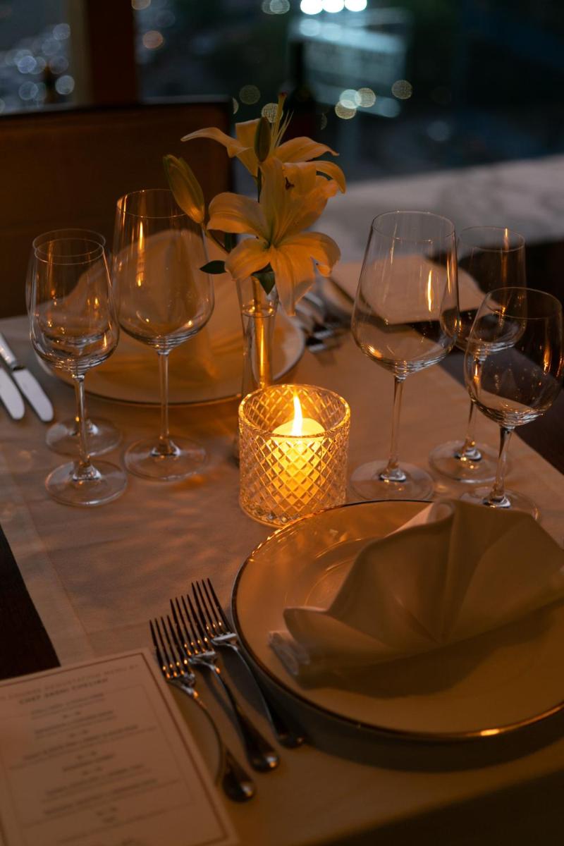 a table with wine glasses and a candle on it at The Leela Ambience Gurugram Hotel & Residences - The Luxury Urban Sanctuary in Gurgaon