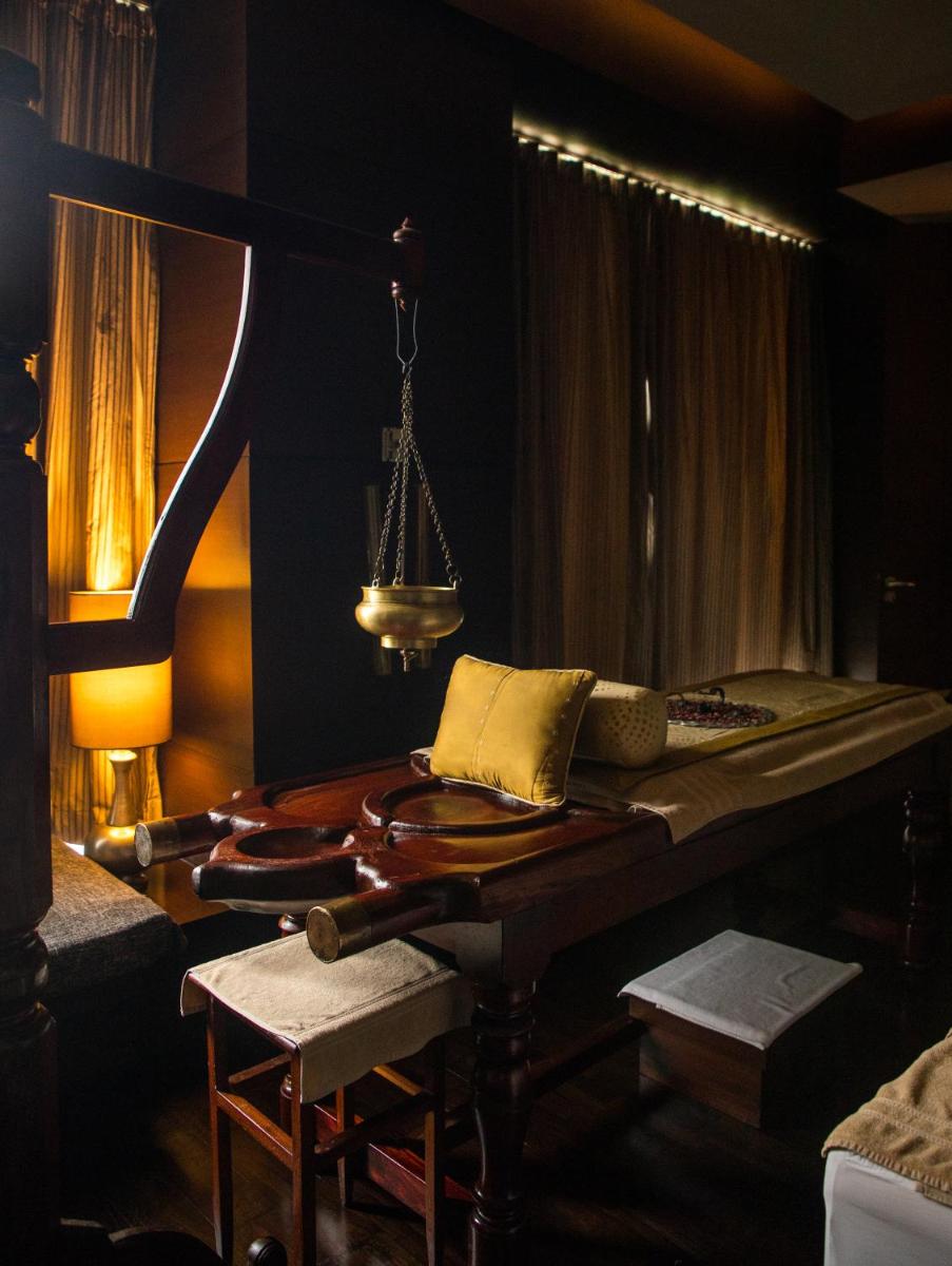 a room with a bed and a table with a lamp at The Leela Ambience Gurugram Hotel & Residences - The Luxury Urban Sanctuary in Gurgaon
