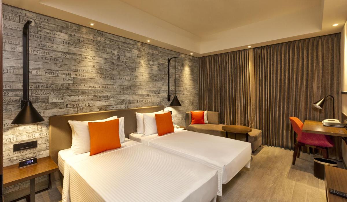 a hotel room with a bed and a desk at Lemon Tree Premier City Center Pune in Pune