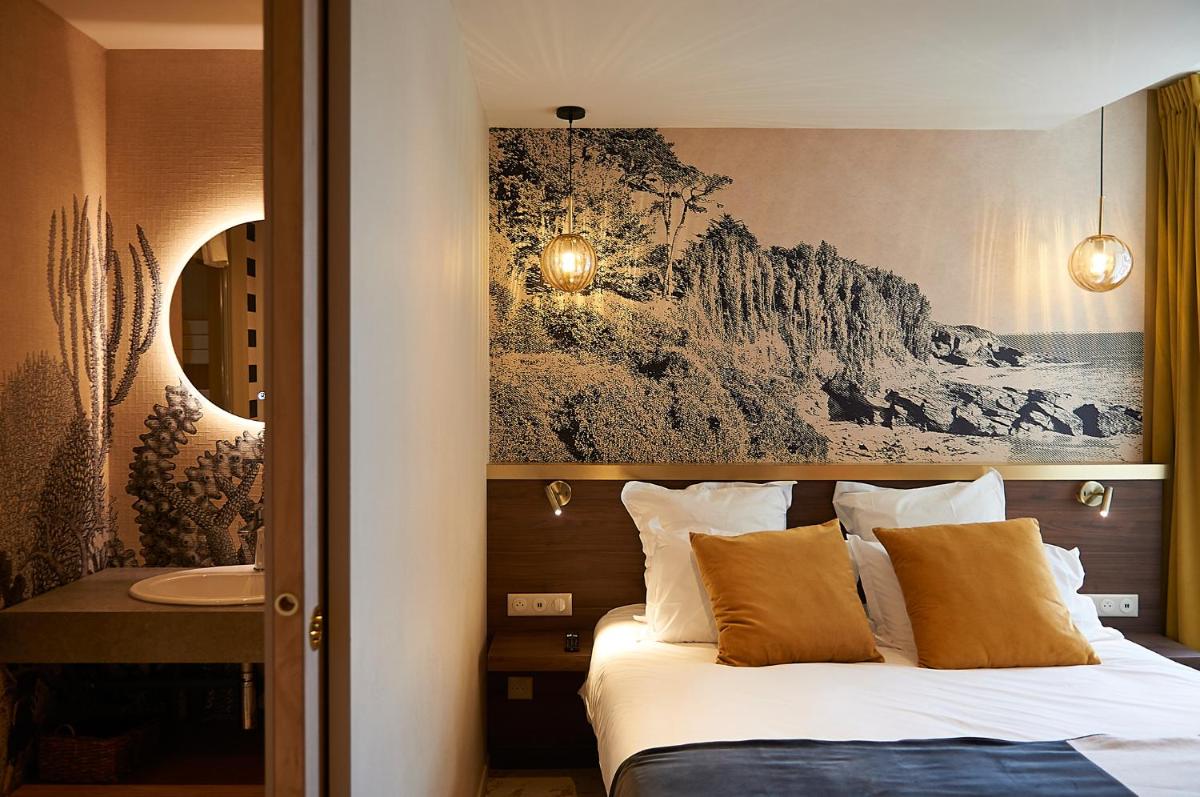 une chambre d'hôtel avec un lit et un lavabo dans l'établissement HOTEL LA MARINE, à Groix