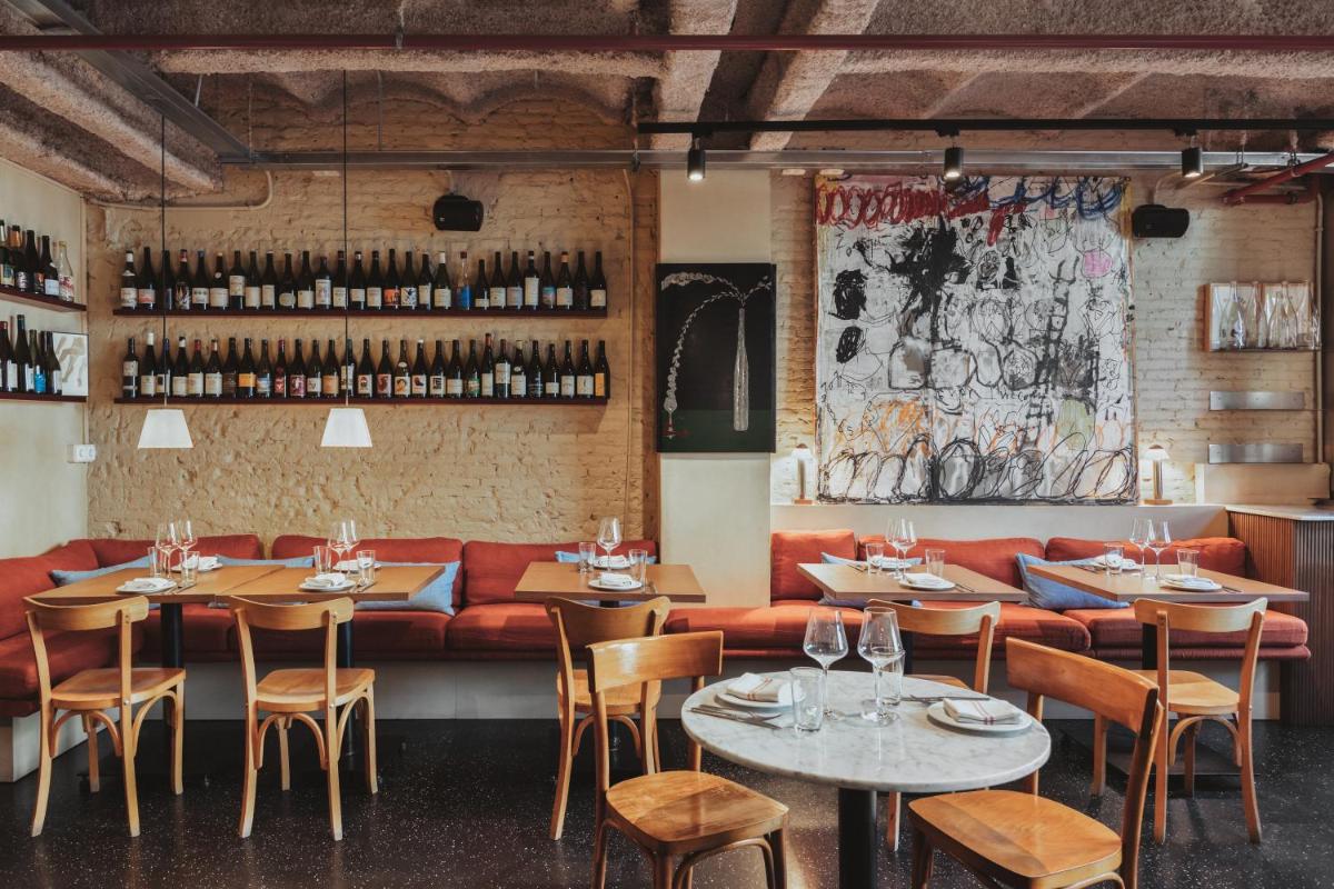 un restaurante con mesas y sillas y un sofá rojo en Hotel Casa Bonay & Spa, en Barcelona
