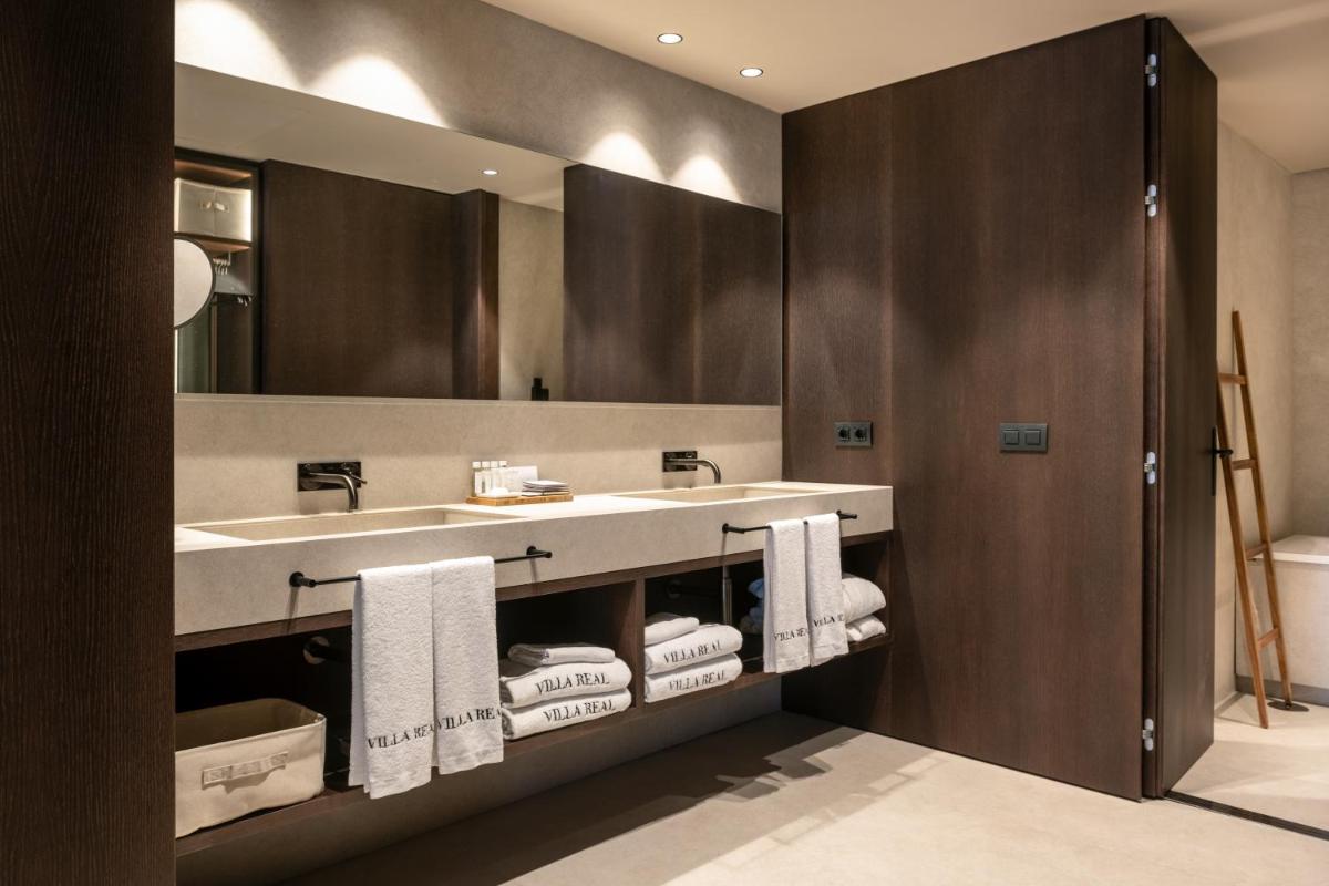 Un baño con lavabo, espejo y toallas. en Hotel Villa Real, a member of Preferred Hotels & Resorts, en Madrid