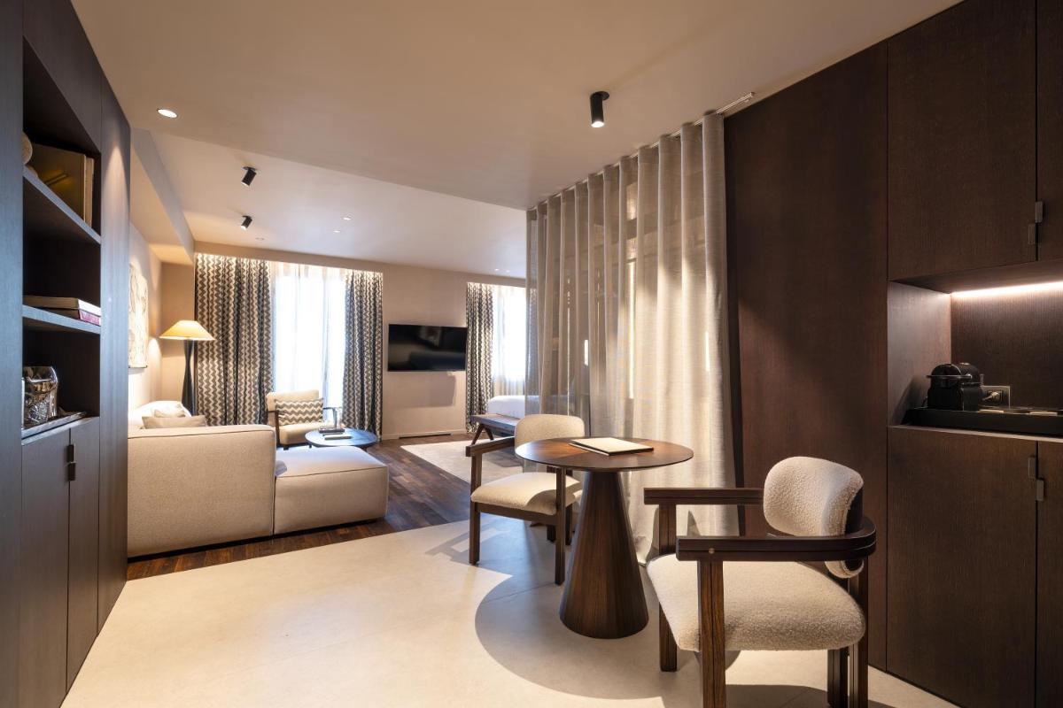 Una sala de estar con una mesa y sillas en una habitación. en Hotel Villa Real, a member of Preferred Hotels & Resorts, en Madrid