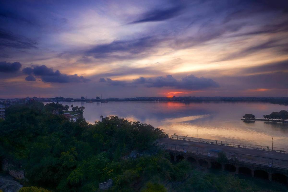 a sunset over a river with a bridge at Hyderabad Marriott Hotel & Convention Centre in Hyderabad