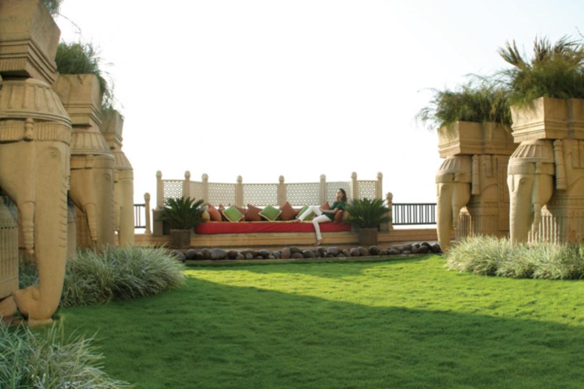 a garden with a bench in the middle of a yard at Hyderabad Marriott Hotel & Convention Centre in Hyderabad