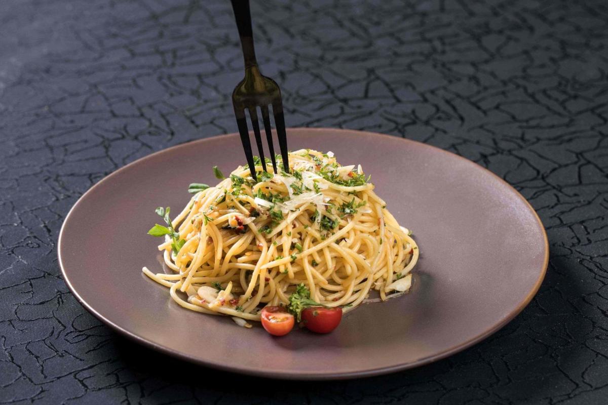 a plate of pasta with a fork on top at Hyderabad Marriott Hotel & Convention Centre in Hyderabad