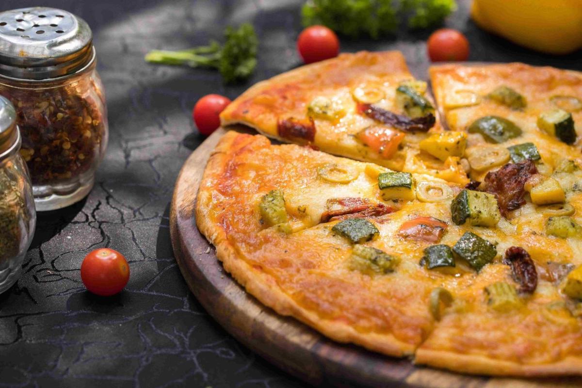 a pizza sitting on top of a wooden table at Hyderabad Marriott Hotel & Convention Centre in Hyderabad