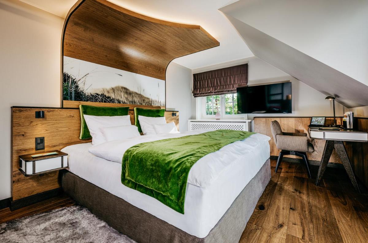 Ein Bett oder Betten in einem Zimmer der Unterkunft Relais & Châteaux Landhaus Stricker