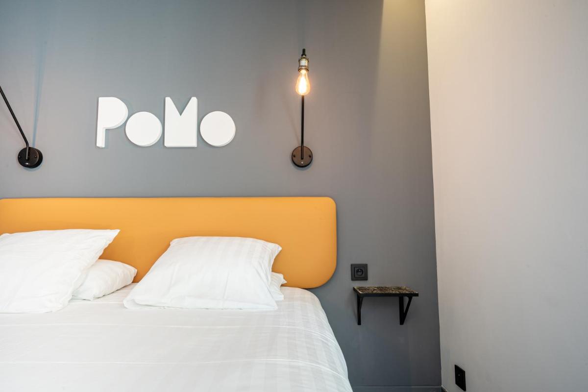 Un ou plusieurs lits dans un hébergement de l'établissement PoMo Hôtel & Restaurant