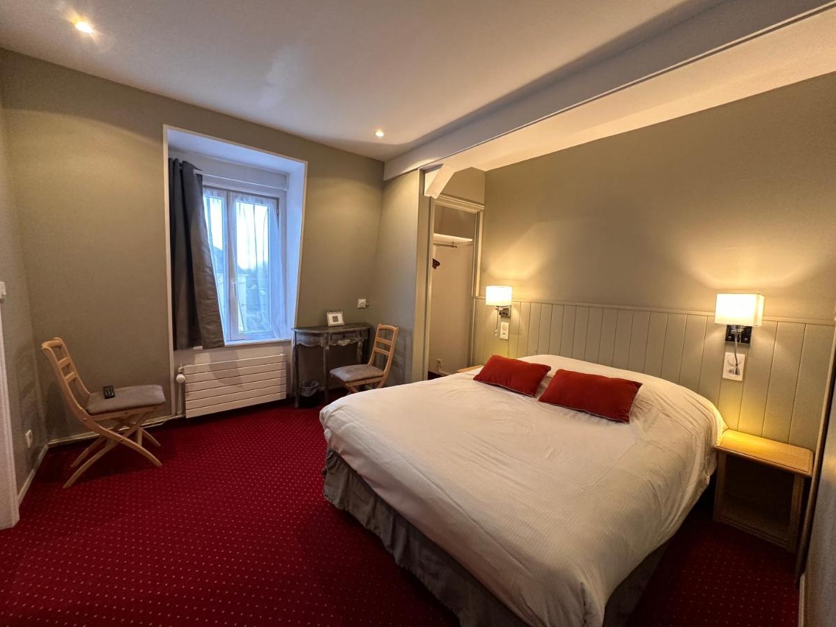 une chambre d'hôtel avec un grand lit et une fenêtre dans l'établissement Hôtel-Spa-Piscine Le Petit Castel Beuzeville-Honfleur, à Beuzeville