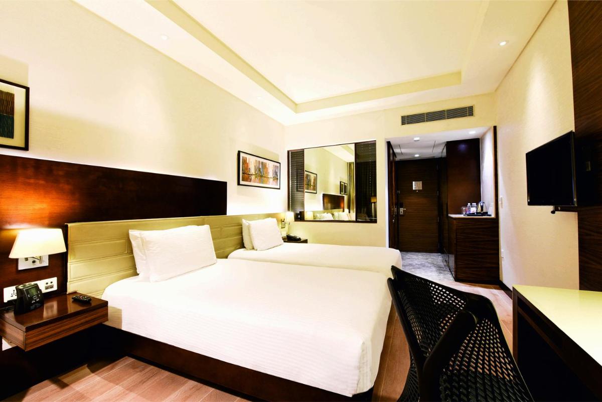 a hotel room with a bed and a desk at DoubleTree by Hilton Gurugram Baani Square in Gurgaon