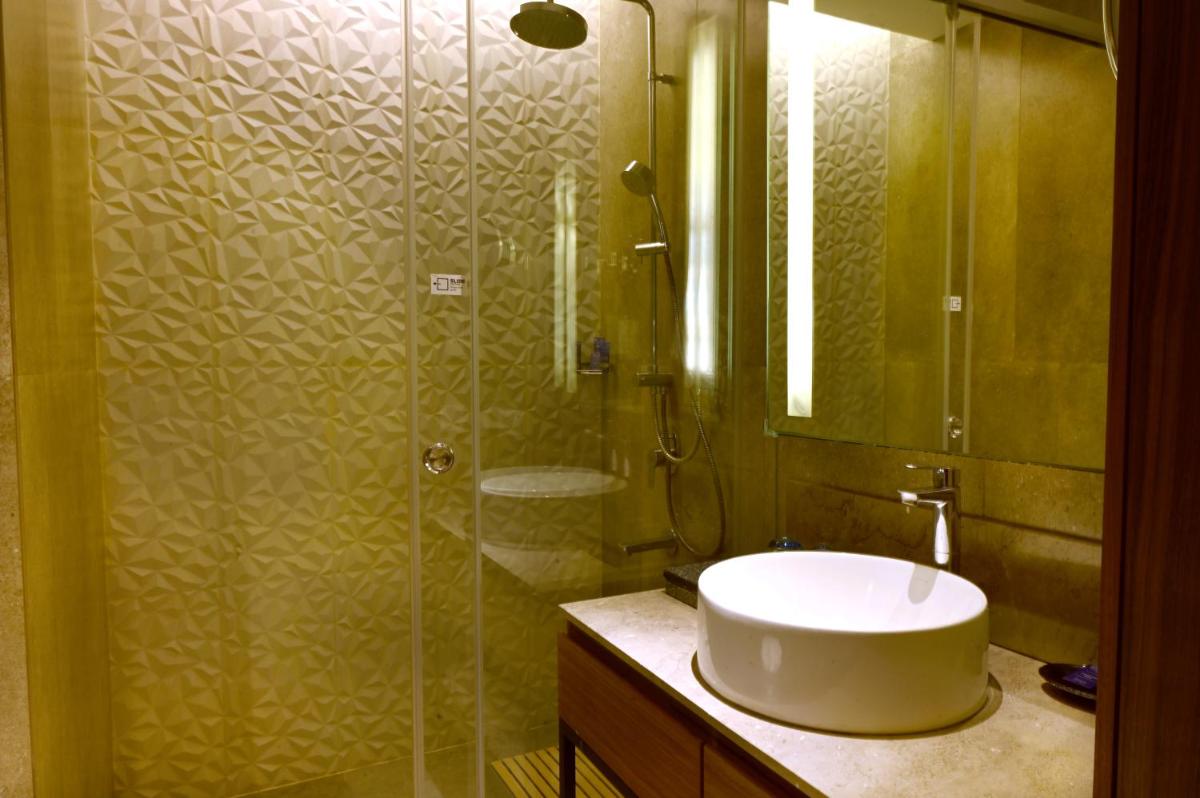 a bathroom with a sink and a glass shower at Vivanta Kolkata EM Bypass in Kolkata
