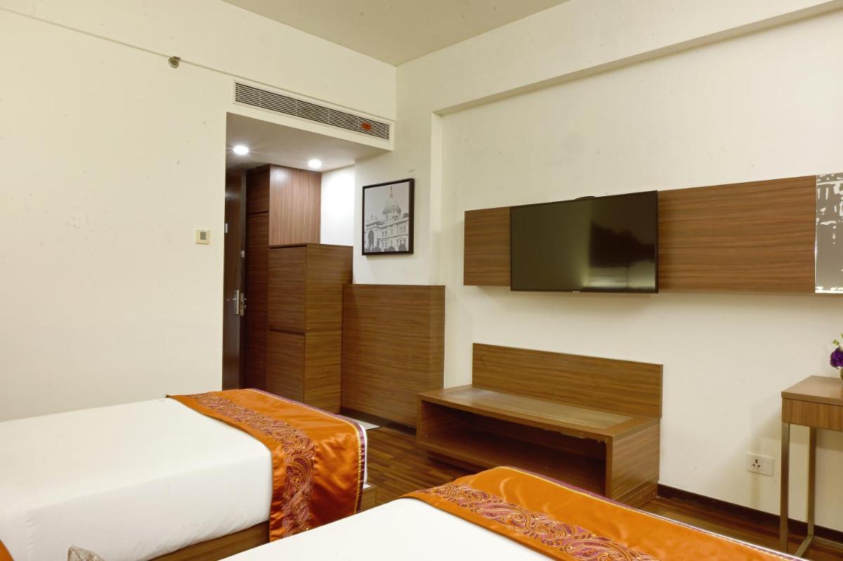 a hotel room with a bed and a flat screen tv at Vivanta Kolkata EM Bypass in Kolkata