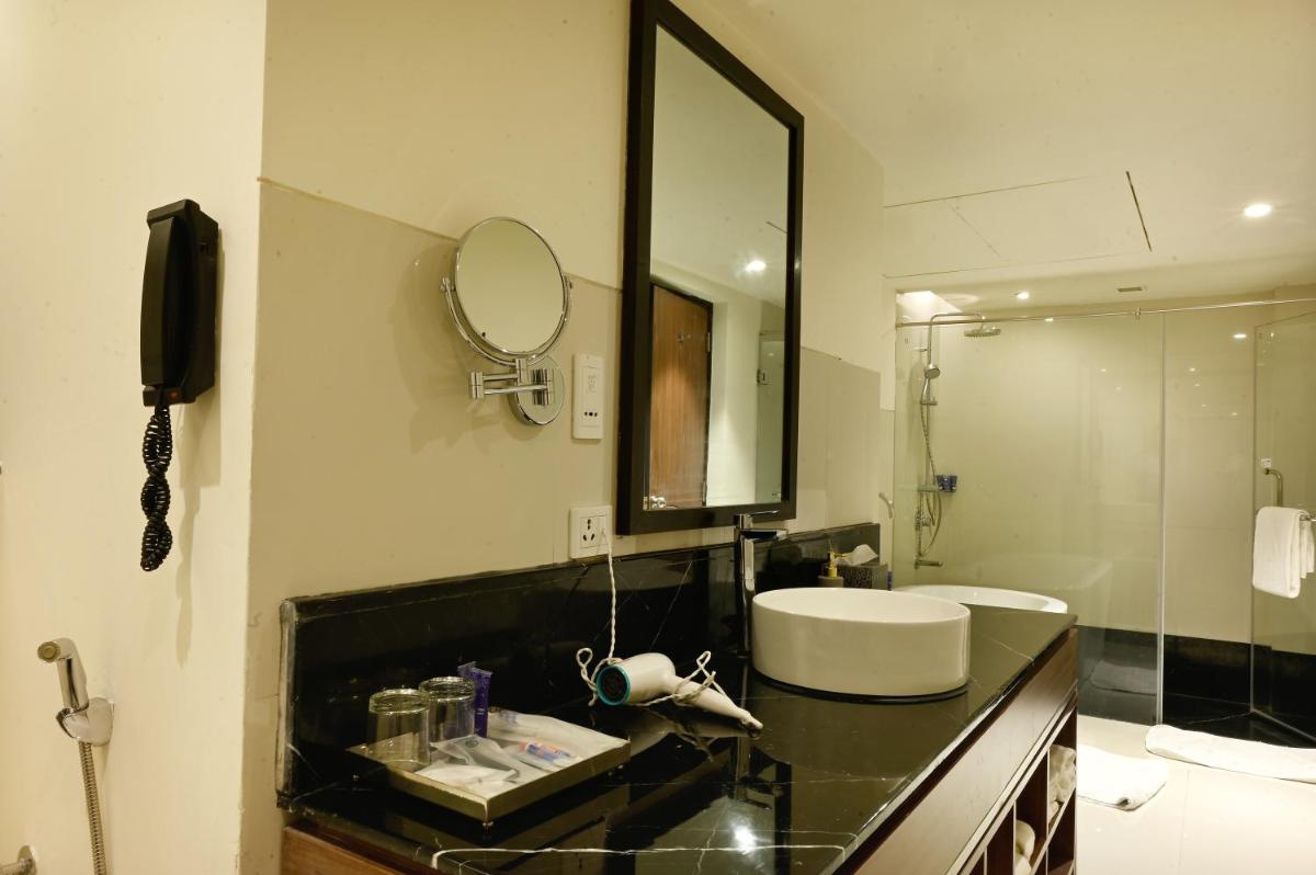a bathroom with a sink and a mirror at Vivanta Kolkata EM Bypass in Kolkata