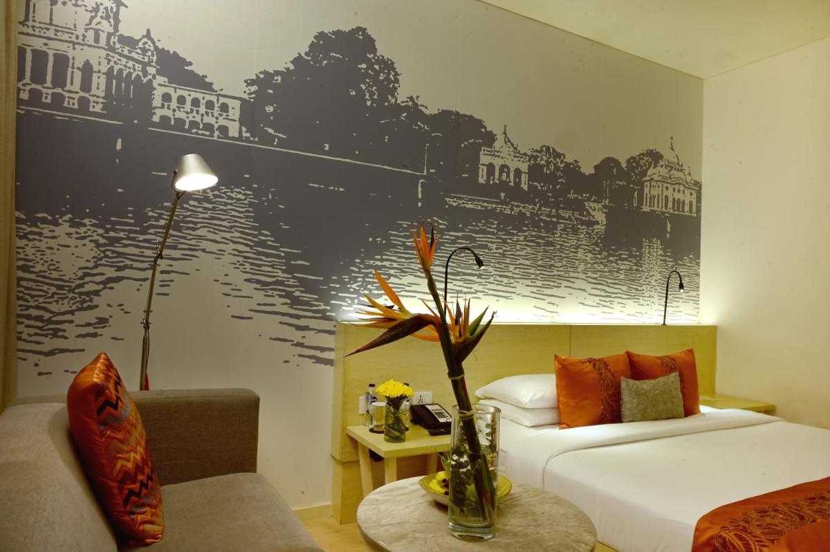a hotel room with a bed and a couch at Vivanta Kolkata EM Bypass in Kolkata