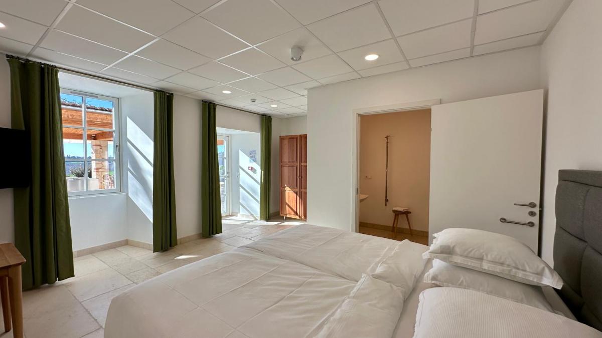 une chambre avec un grand lit blanc et une fenêtre dans l'établissement Château Lecusse - La Grande Roche - Hôtel, Spa, Boutique & Restaurant, à Broze 44 autres photos