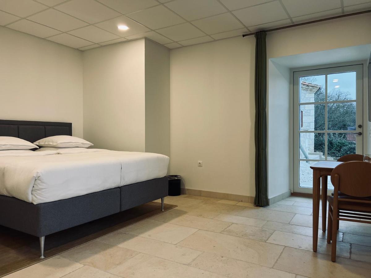 Un ou plusieurs lits dans un hébergement de l'établissement Château Lecusse - La Grande Roche - Hôtel, Spa, Boutique & Restaurant
