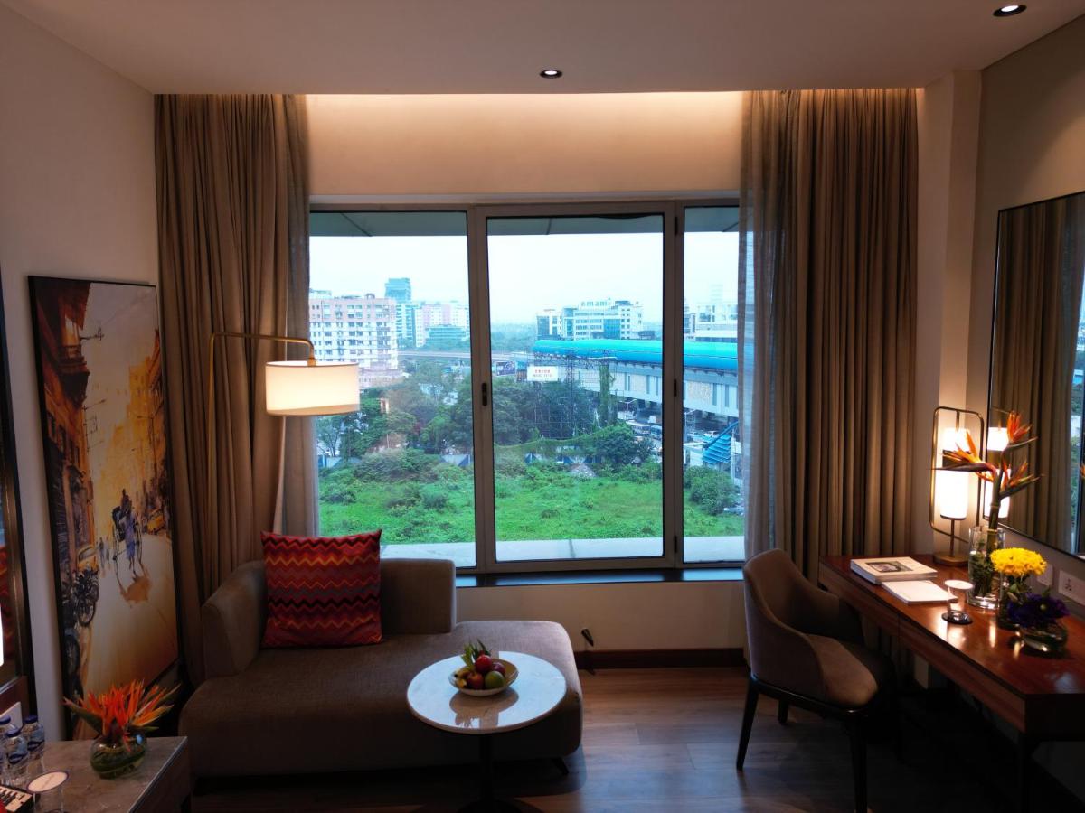 a living room with a couch and a large window at Vivanta Kolkata EM Bypass in Kolkata