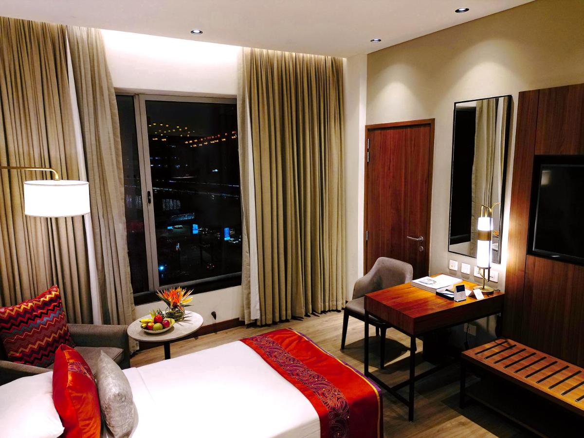 a hotel room with a bed and a desk at Vivanta Kolkata EM Bypass in Kolkata