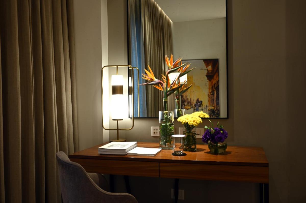 a desk in a hotel room with flowers on it at Vivanta Kolkata EM Bypass in Kolkata