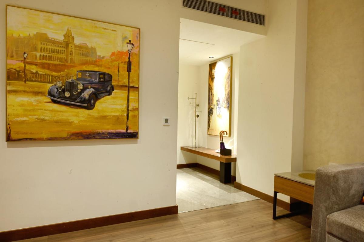 a living room with a painting of a car on the wall at Vivanta Kolkata EM Bypass in Kolkata