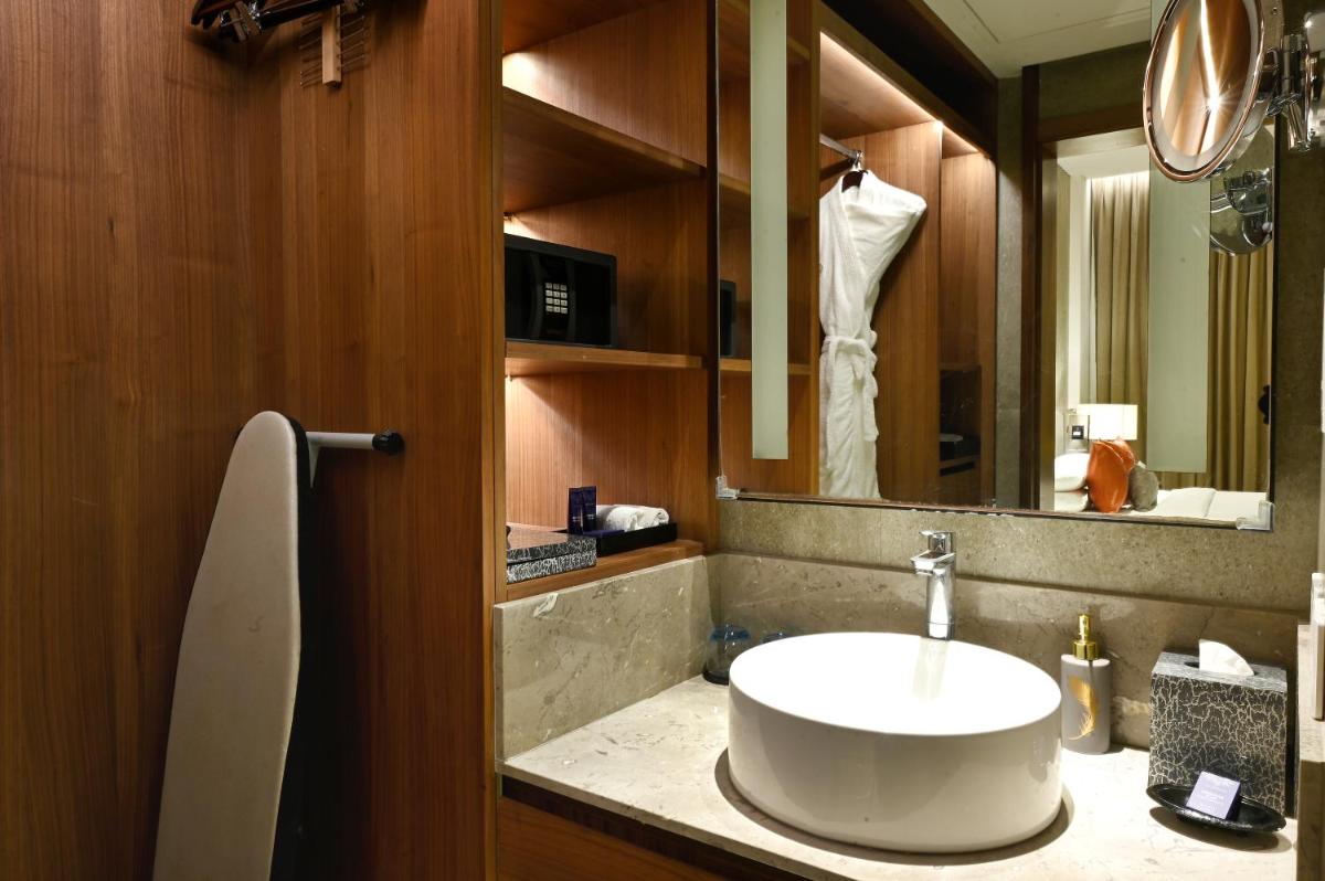 a bathroom with a sink and a mirror at Vivanta Kolkata EM Bypass in Kolkata