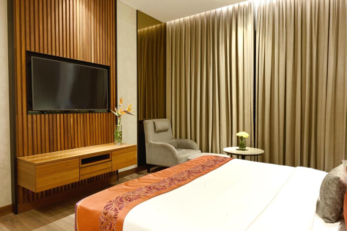 a hotel room with a bed and a flat screen tv at Vivanta Kolkata EM Bypass in Kolkata